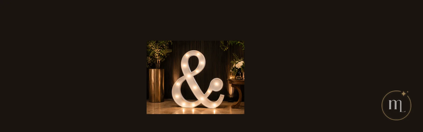 Un ampersand iluminado apoyado en el piso, con el reflejo de sus focos