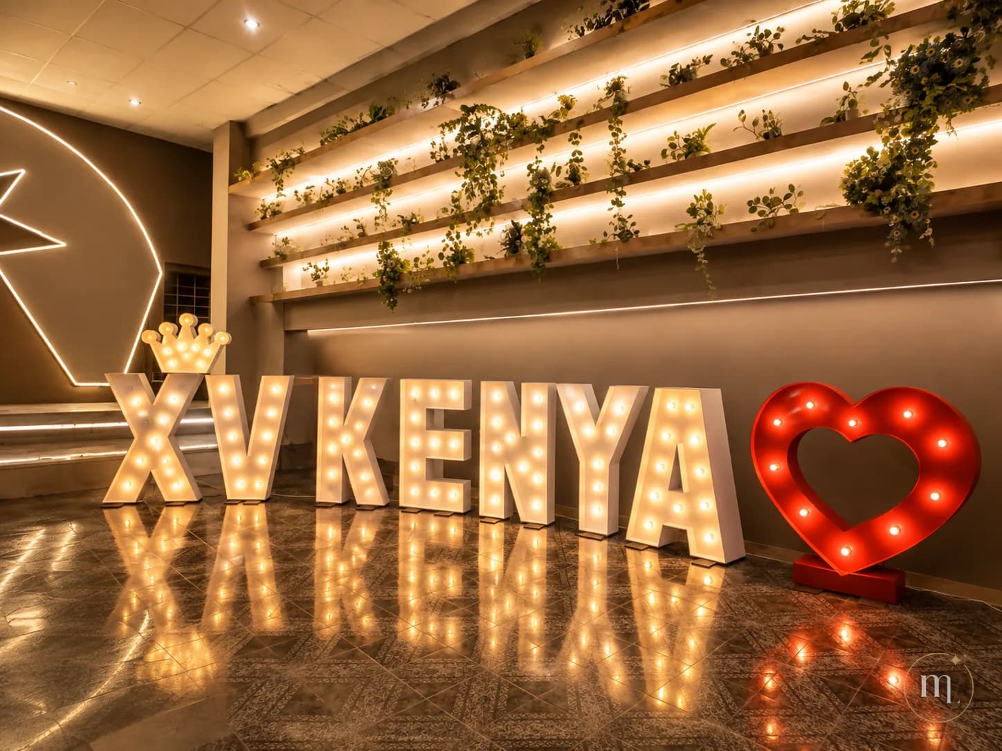 XV KENYA en letras iluminadas, con la corona sobre la X y el corazón rojo al lado, reflejándose en el piso
